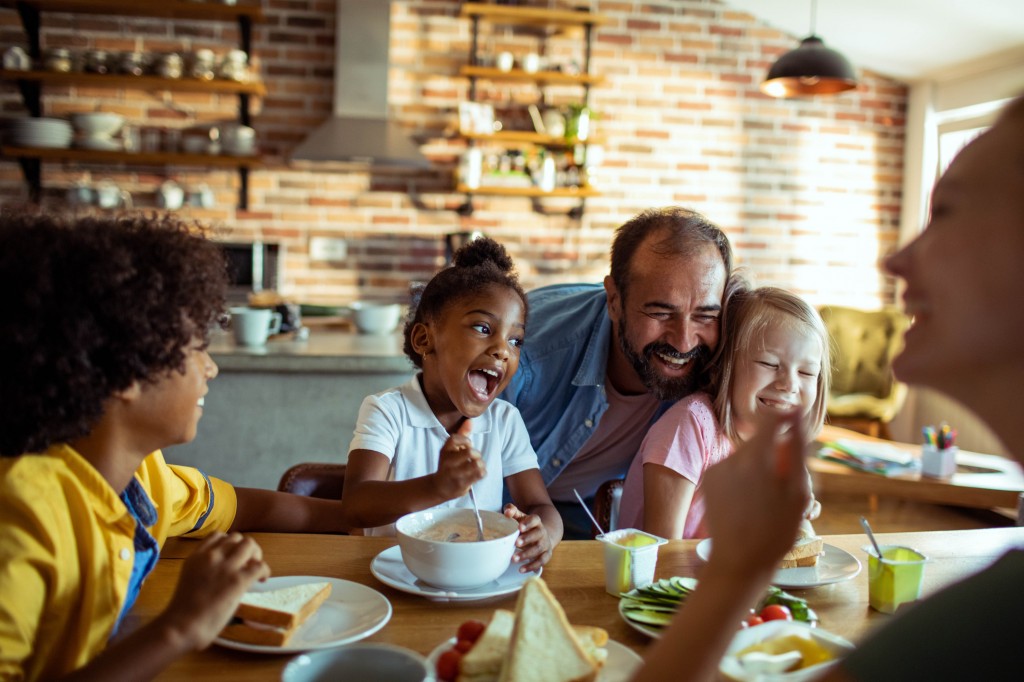 A family that incudes adoptive children enjoys a meal.