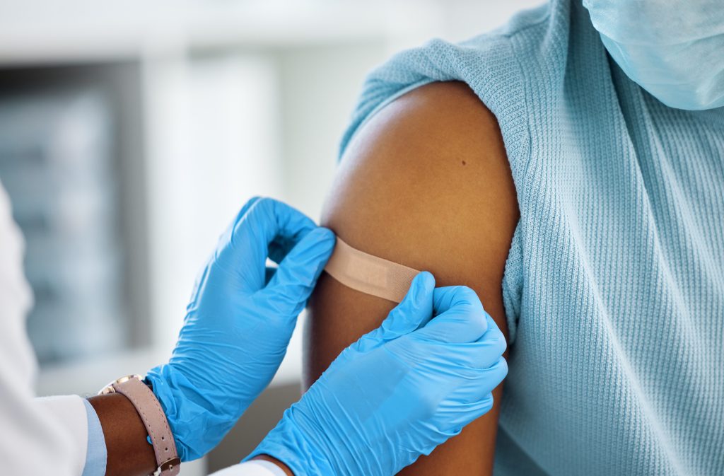 Woman receiving bandage after COVID-19 vaccination.