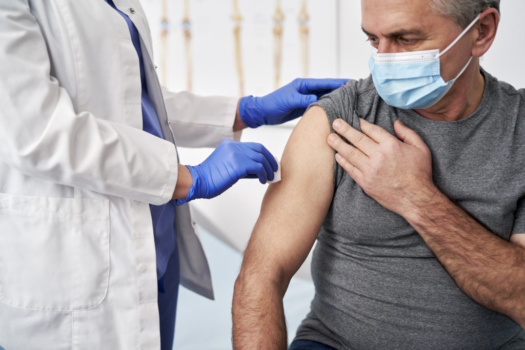 Older man receiving COVID-19 vaccination.